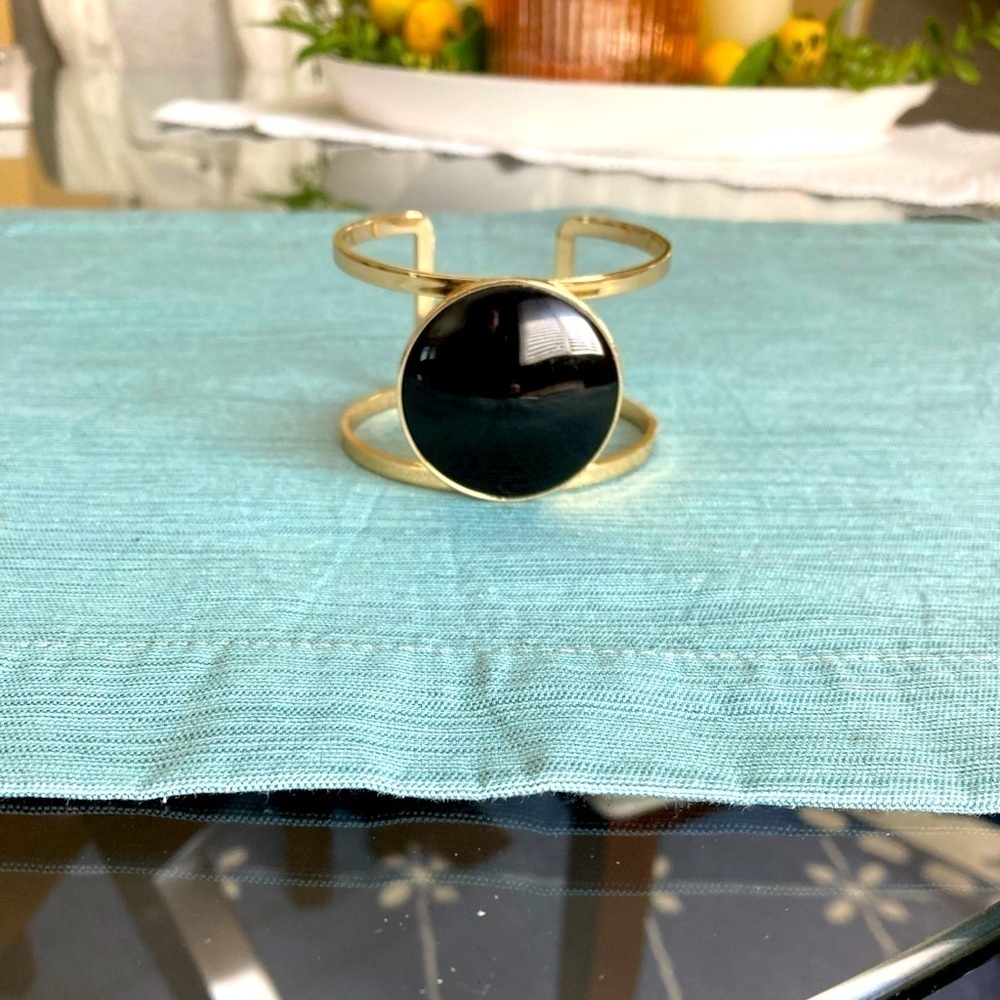 Gold bangle with round black centerpiece